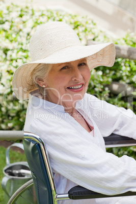 Mature woman in her wheelchair in the garden