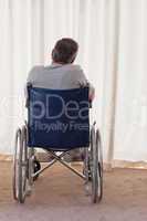 Mature man in his wheelchair with his back to the camera
