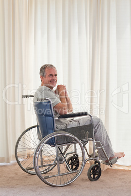 Smiling man in his wheelchair at home
