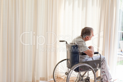Man in his wheelchair looking out the window