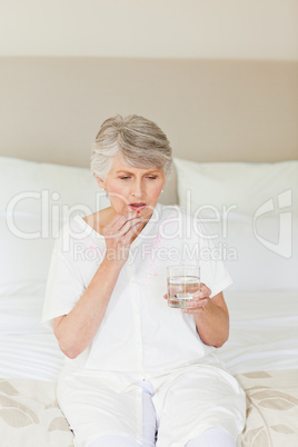 Sick senior woman taking her pills