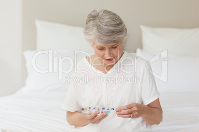 Sick senior woman taking her pills