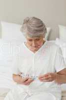 Sick senior woman taking her pills