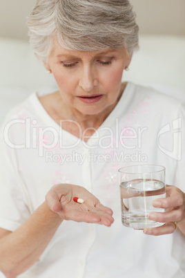 Sick senior woman taking her pills