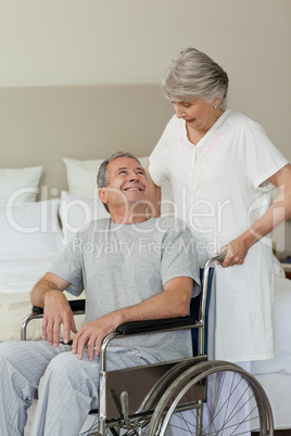 Retired man in his wheelchair with his wife