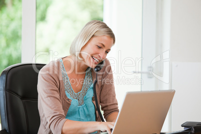 Woman working on her computer while she is phoning