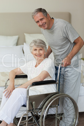 Retired woman in her wheelchair with her husband