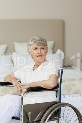 Concentrated senior woman in her wheelchair at home