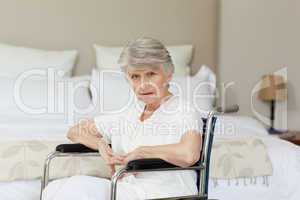 Concentrated senior woman in her wheelchair at home