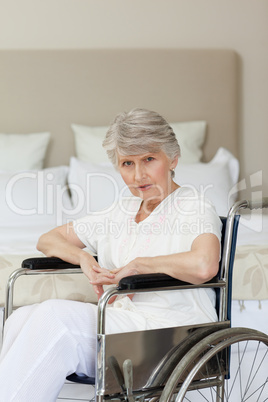 Concentrated senior woman in her wheelchair at home