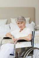 Concentrated senior woman in her wheelchair at home