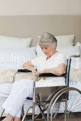 Senior woman asleep in her wheelchair at home