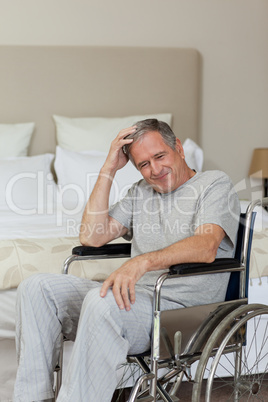 Smiling senior man in his wheelchair  at home