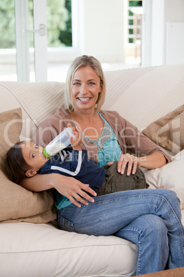 Mother giving a  bottle of milk to her son