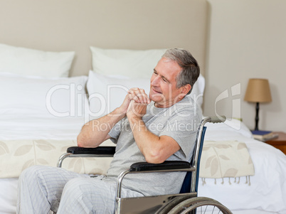 Smiling senior man in his wheelchair  at home