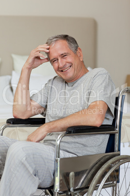 Smiling senior man in his wheelchair  at home