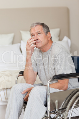 Thoughtful senior man in his wheelchair