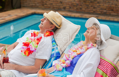 Retired couple sleeping beside the swimming pool