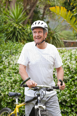 Mature man walking with his mountain bike