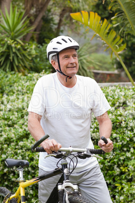 Mature man walking with his mountain bike