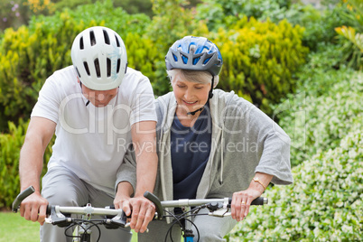 Mature couple mountain biking outside