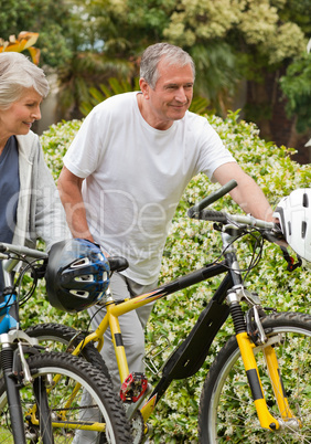 Mature couple walking with their bikes