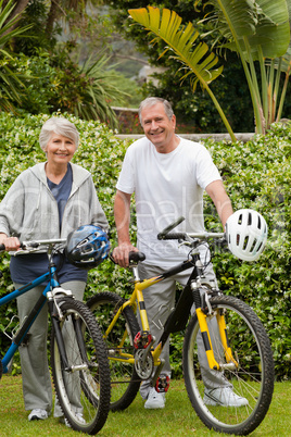 Mature couple walking with their bikes