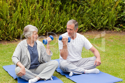 Mature couple doing their exercises in the garden