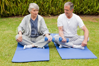 Mature couple doing their exercises in the garden