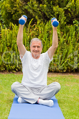 Retired man doing his exercises in the garden