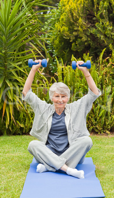 Retired woman doing her exercises in the garden