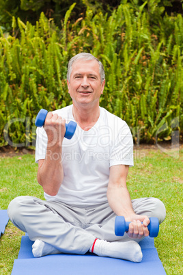 Retired man doing his exercises in the garden