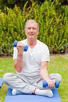 Retired man doing his exercises in the garden