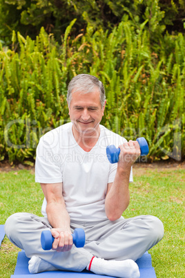 Retired man doing his exercises in the garden