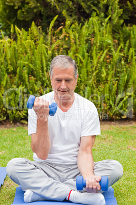 Retired man doing his exercises in the garden