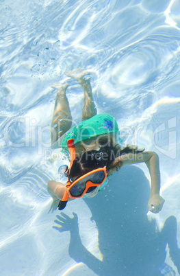 Girl Child Swimming Underwater in Pool with Goggles and Snorkel