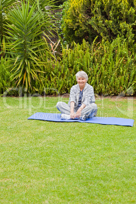 Senior woman doing her streches in the garden