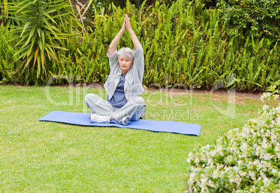 Senior woman doing her streches in the garden