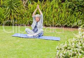 Senior woman doing her streches in the garden