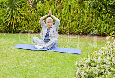 Senior woman doing her streches in the garden