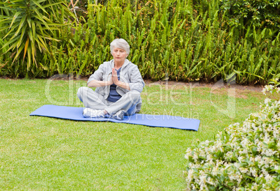 Senior woman doing her streches in the garden