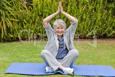 Senior woman doing her streches in the garden