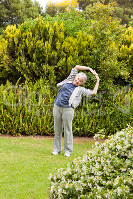 Retired  woman doing her streches in the garden