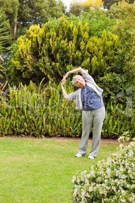 Retired  woman doing her streches in the garden