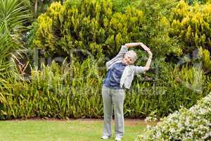 Retired  woman doing her streches in the garden