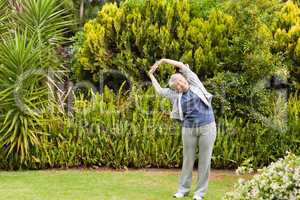 Retired  woman doing her streches in the garden