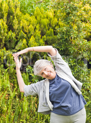 Mature woman doing her streches in the garden