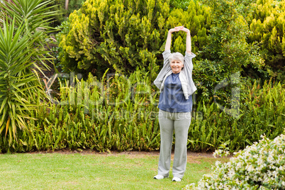 Retired  woman doing her streches in the garden