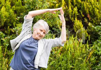 Mature woman doing her streches in the garden