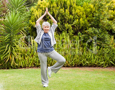 Mature woman doing her streches in the garden